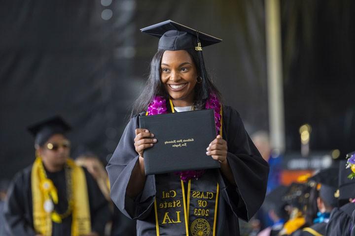 A student holds her diploma at graduation ceremony.